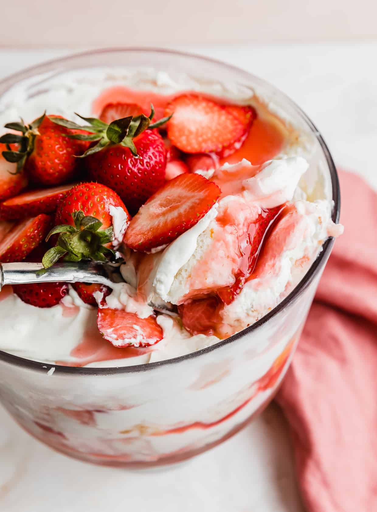 A serving spoon scooping out homemade Strawberry Shortcake Trifle.