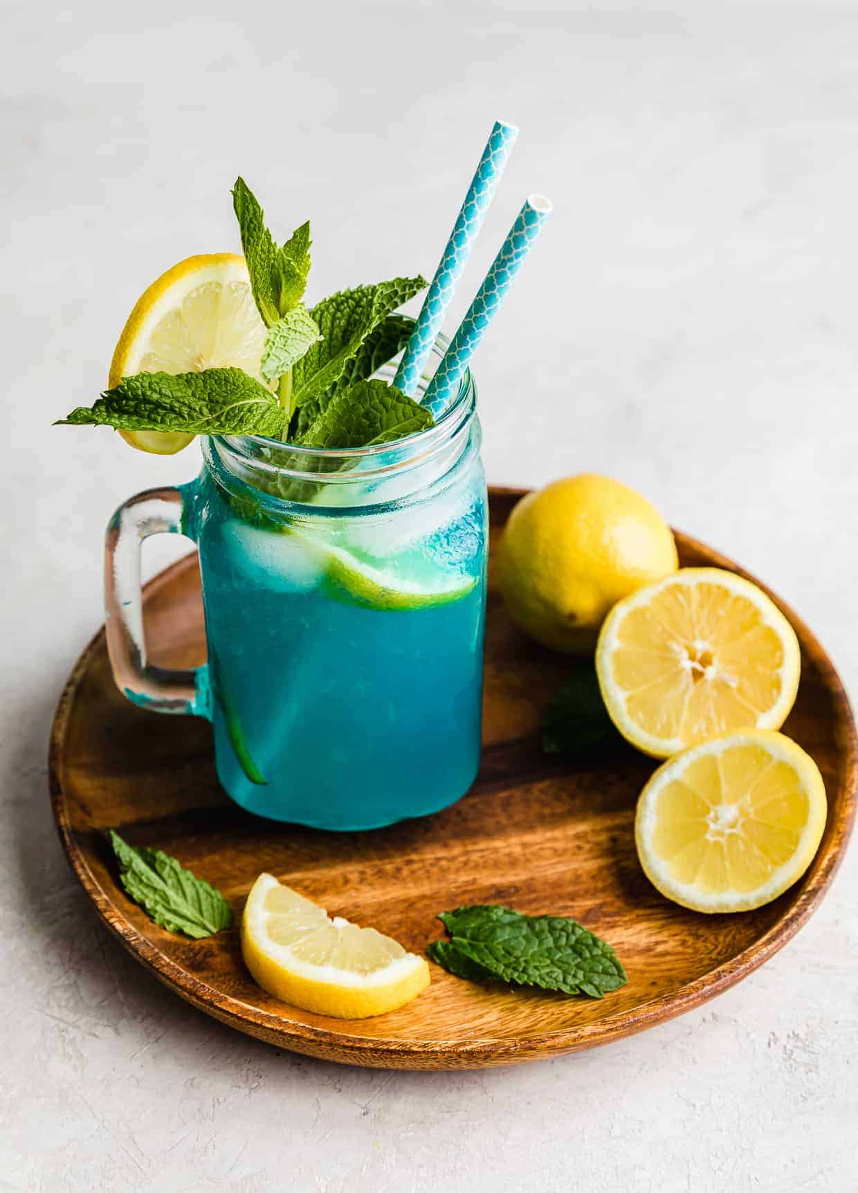 Lemonade. Glass jug with lemonade and lemon slices on a white