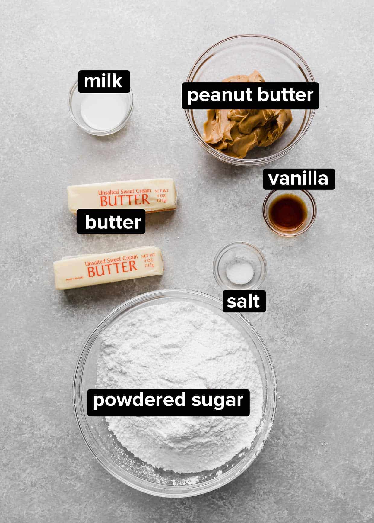 Ingredients used to make peanut butter frosting on a gray background. 