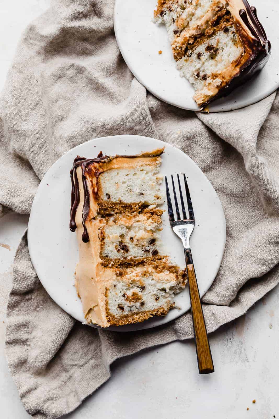 A slice of 7 Layer Bar Cake on a white plate with a fork next to the cake.