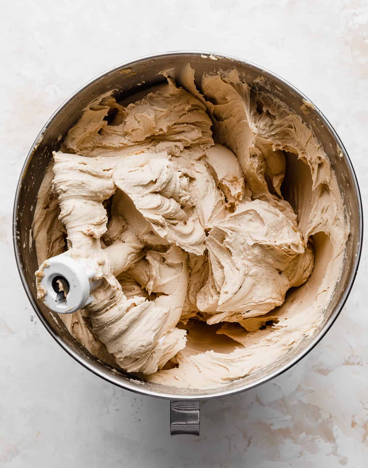 A metal mixing bowl with cookie butter Biscoff buttercream in it. 