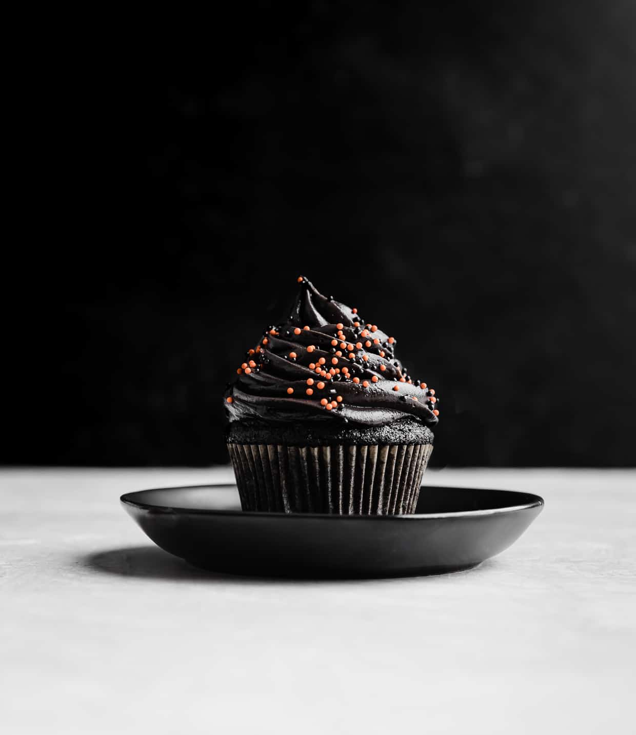 A single Black Velvet Cupcakes on a black plate.