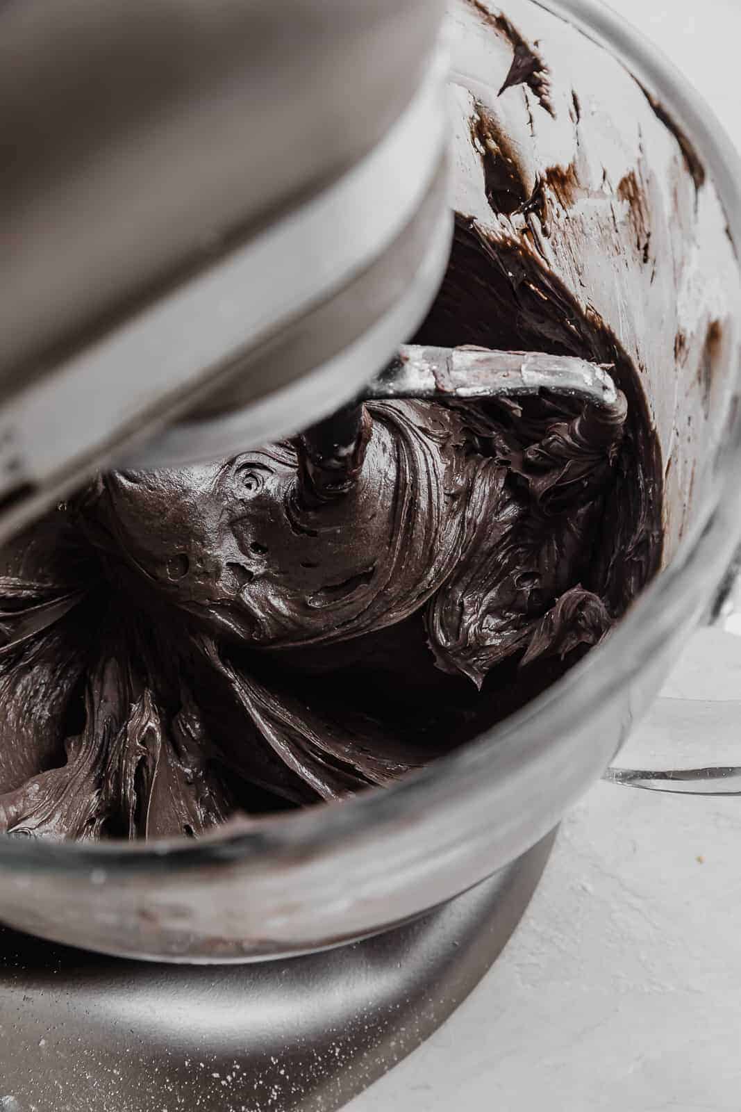 A stand mixer stirring Black Velvet Cupcake frosting.