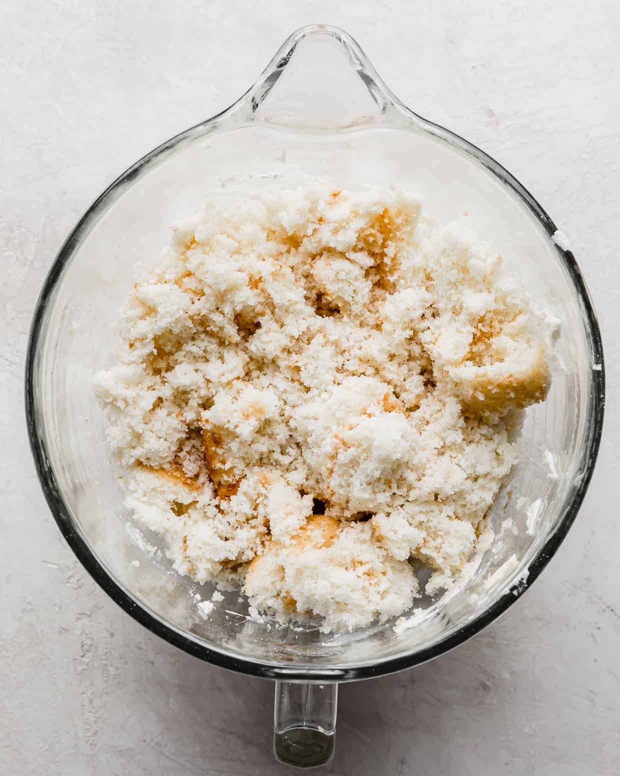 Crumbled white cake in a mixing bowl.