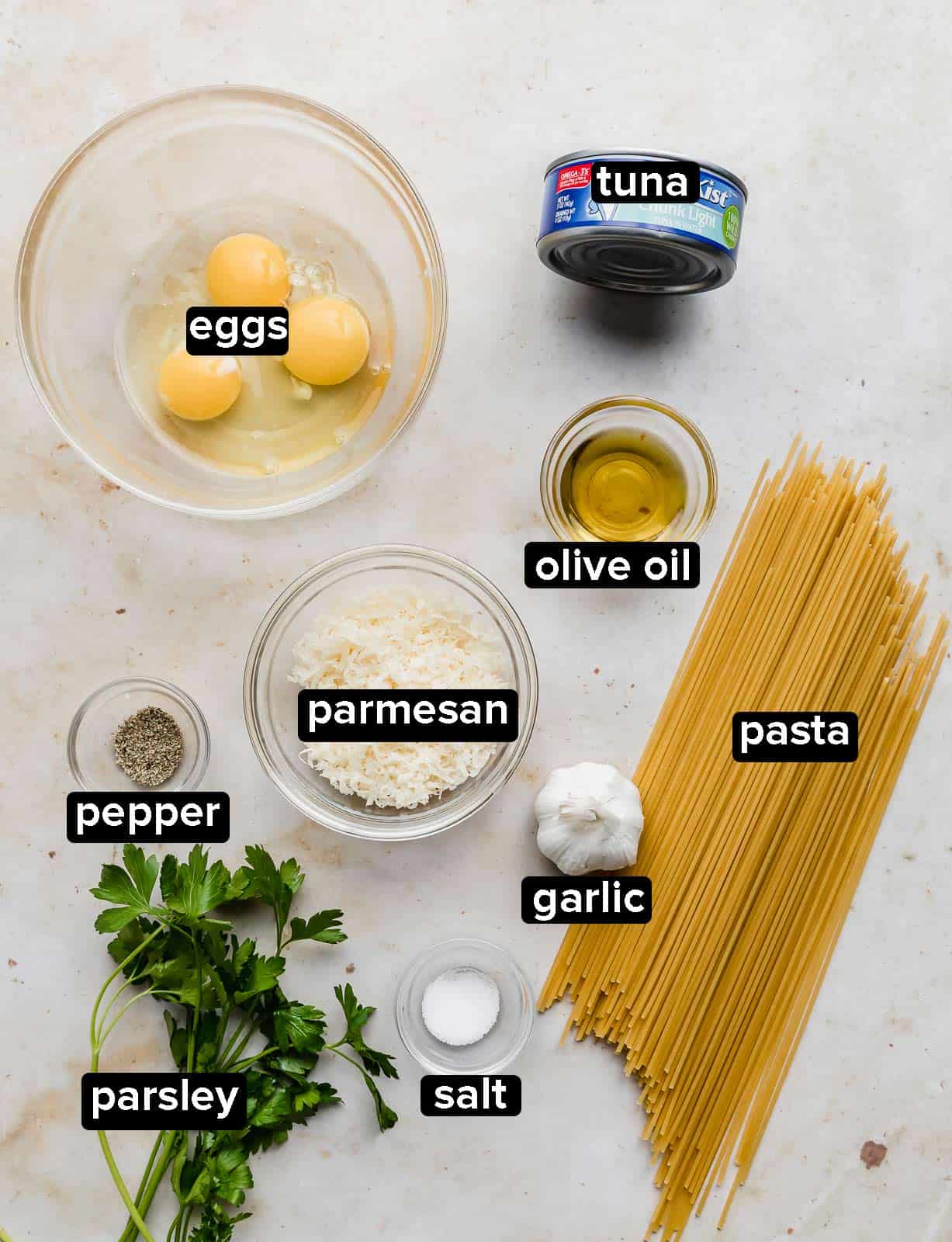 Ingredients used to make Tuna Carbonara on a white background. 