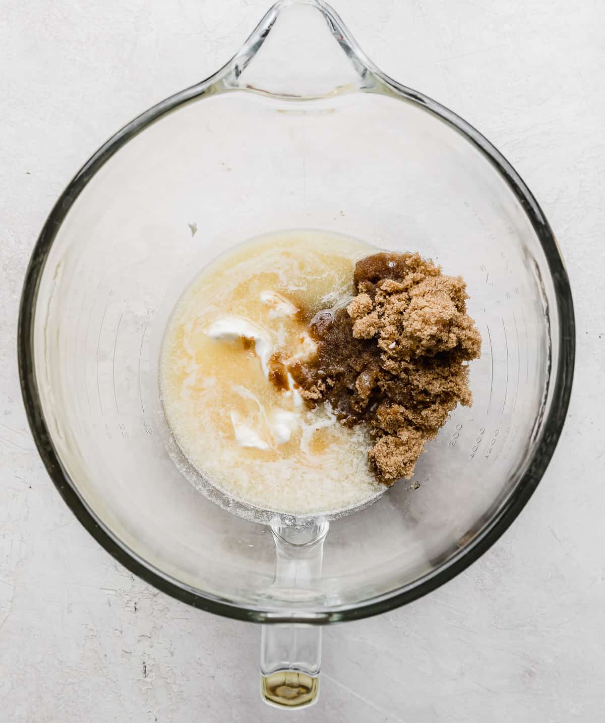 A glass bowl with melted butter, brown sugar, vanilla in it.