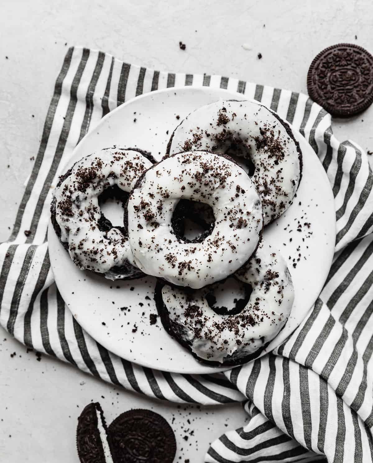 A white plate with four Oreo donuts on it.