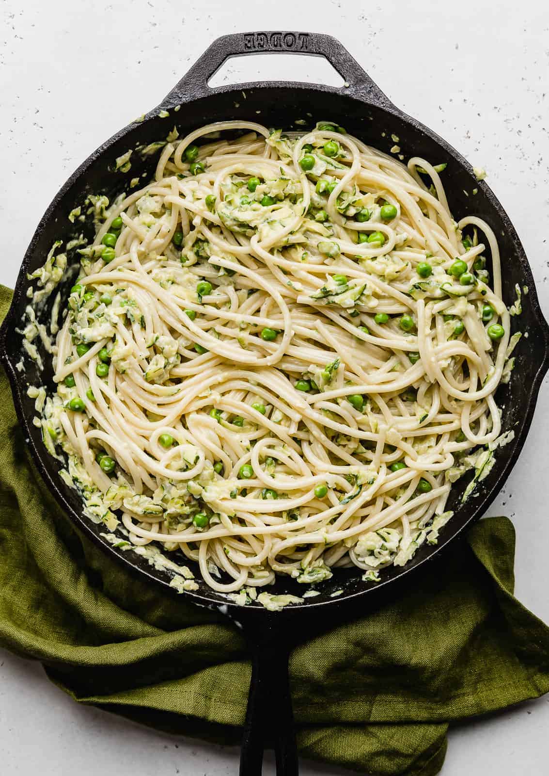 Pasta with Zucchini Sauce in a black skillet against a white background.