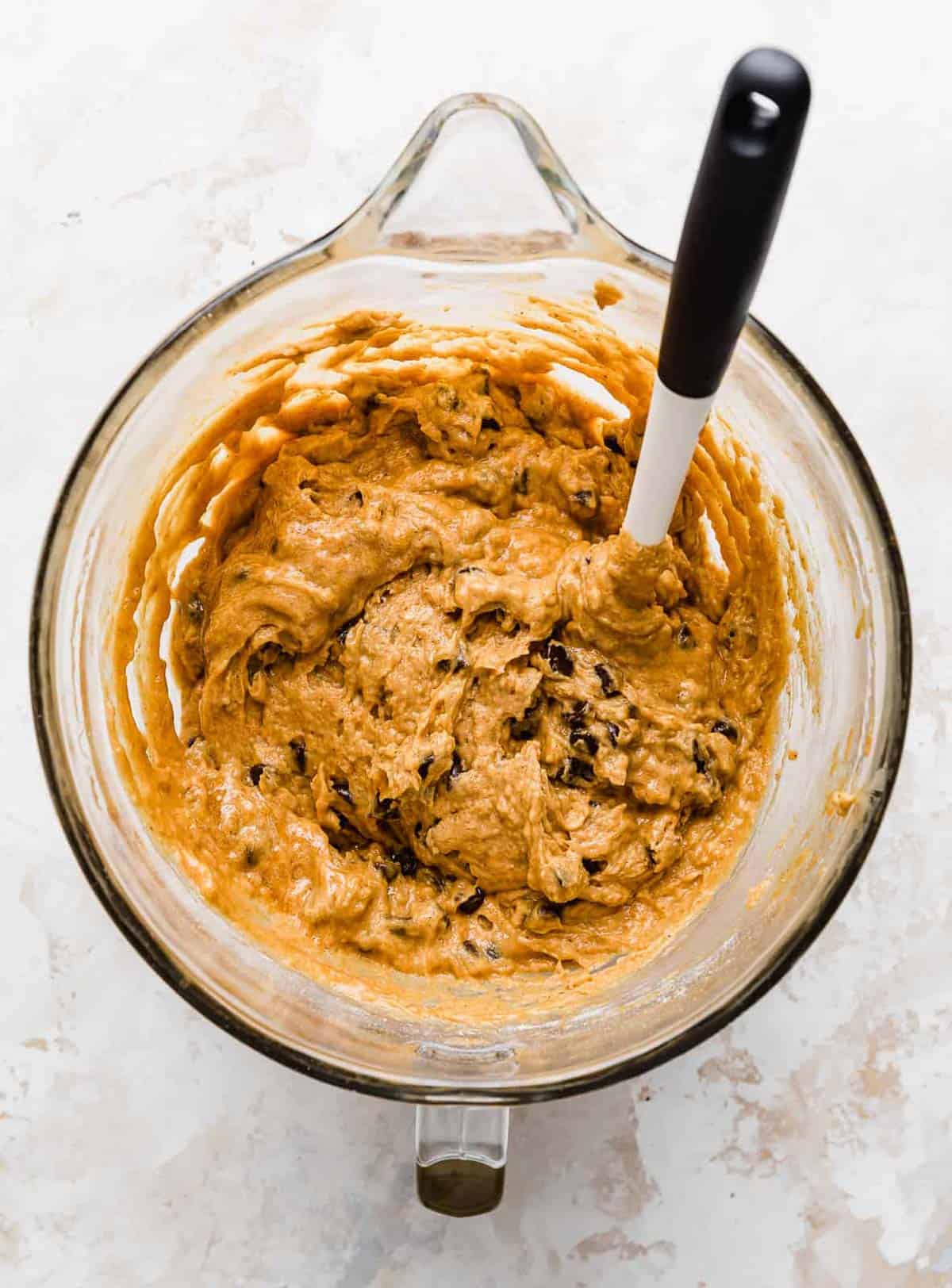 Pumpkin Chocolate Chip Coffee Cake batter with a spatula in a mixing bowl.