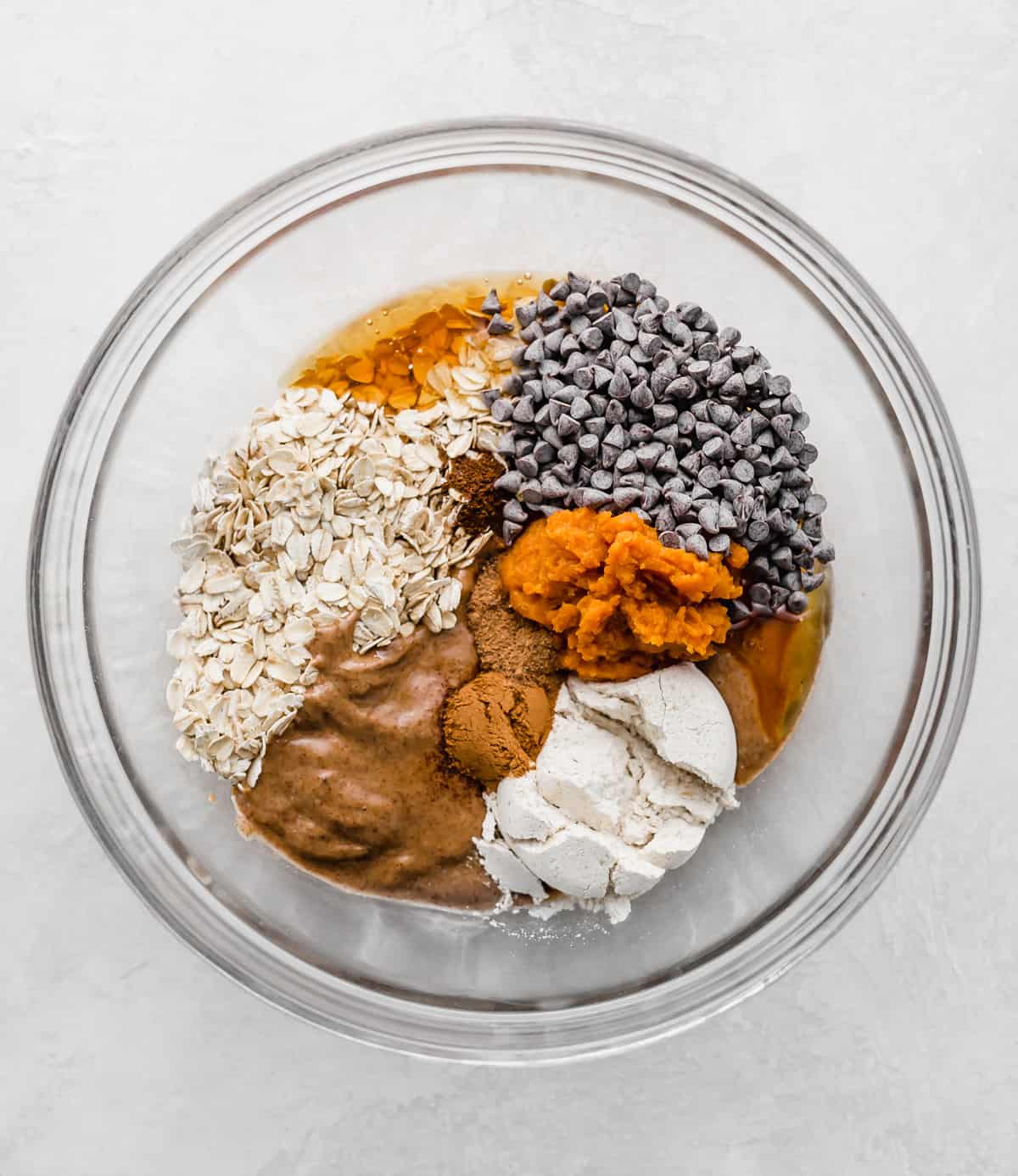 ingredients used to make pumpkin energy balls in a glass bowl.