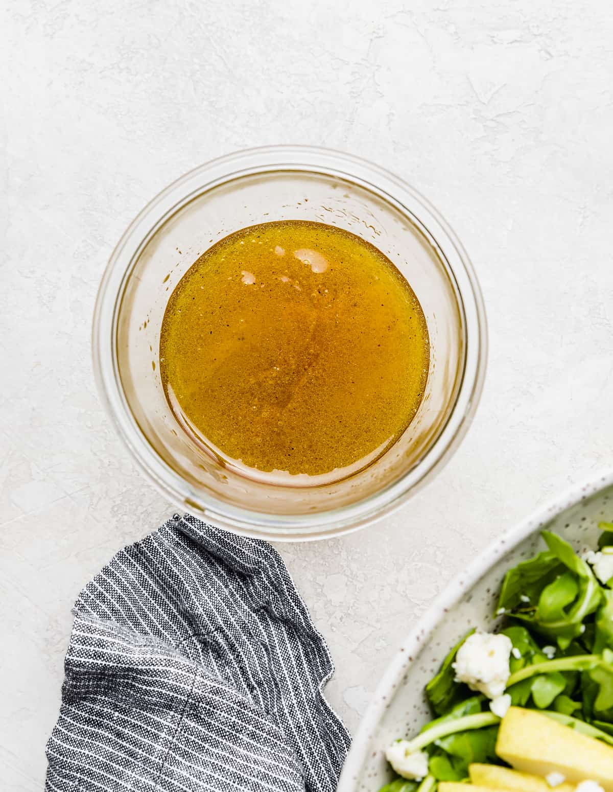 Rocket and Pear Salad dressing in a glass jar on a white background.
