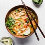 A bowl of Thai Red Curry Noodle Soup on a white background.