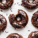 Chocolate Doughnuts on a white background with a bite taken out of it.