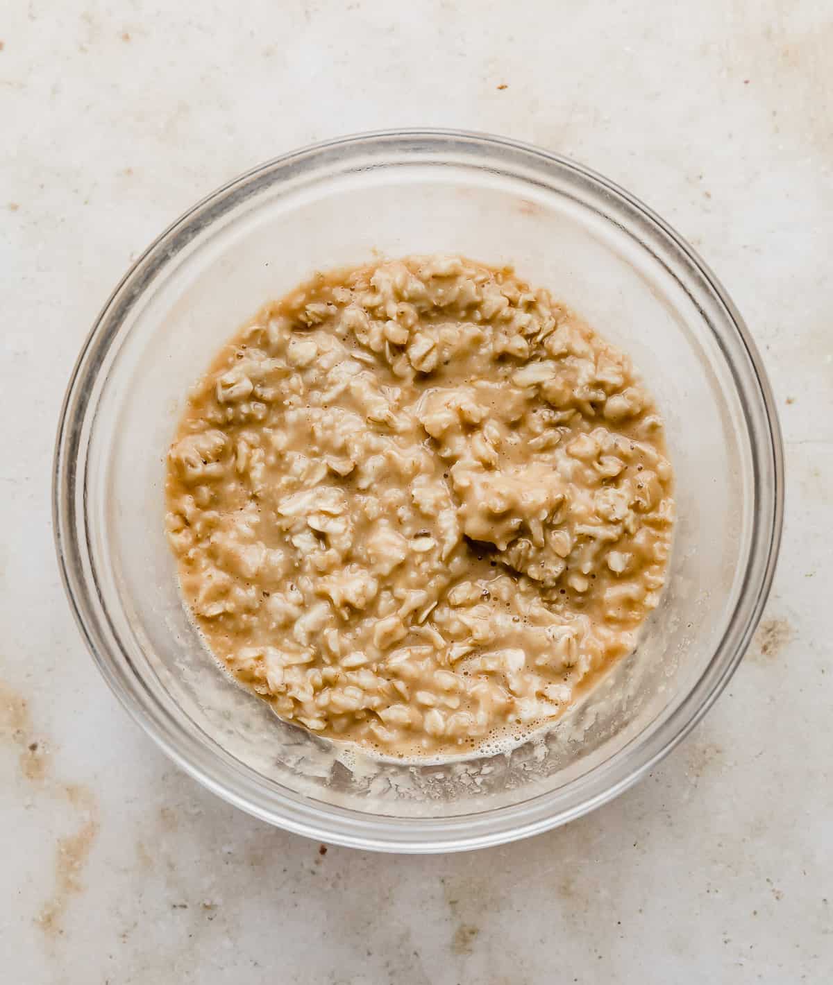 A glass bowl with peanut butter oatmeal in it.