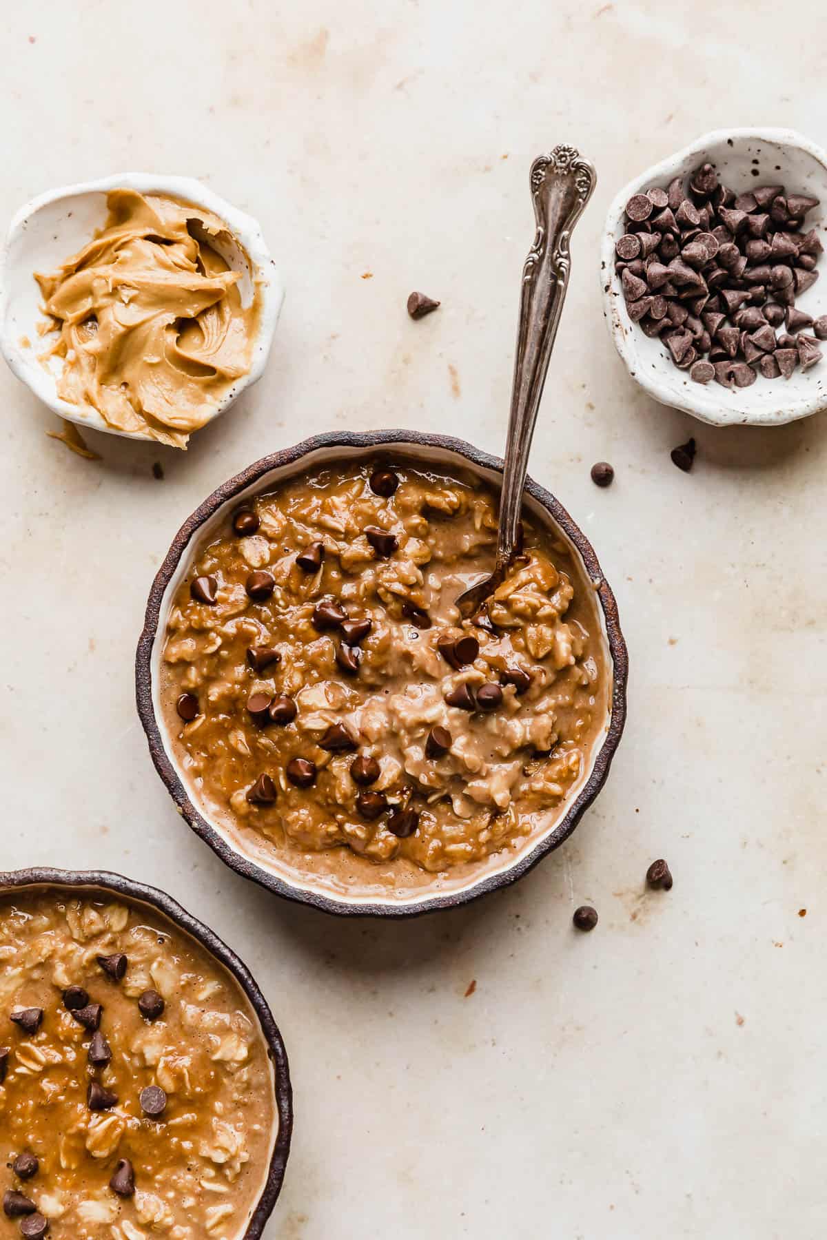 A black rimmed bowl full of Chocolate Peanut Butter Protein Oatmeal  that is topped with mini chocolate chips.