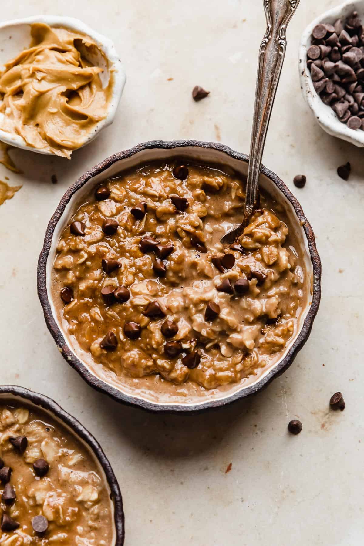 A black bowl full of Chocolate Peanut Butter Protein Oatmeal  topped with mini chocolate chips.
