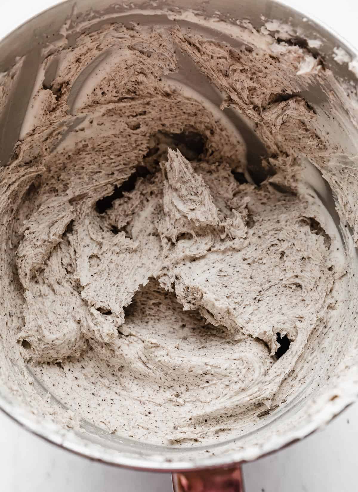 A cookies and cream buttercream in a metal mixing bowl.