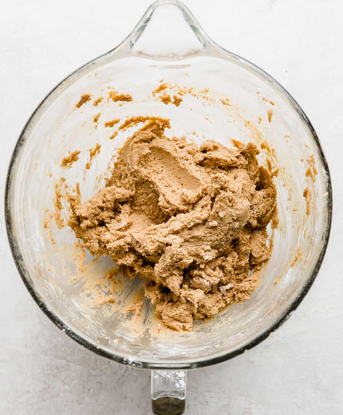 Crumbl Cookie Dough Cookie dough (medium brown in color) in a glass mixing bowl.