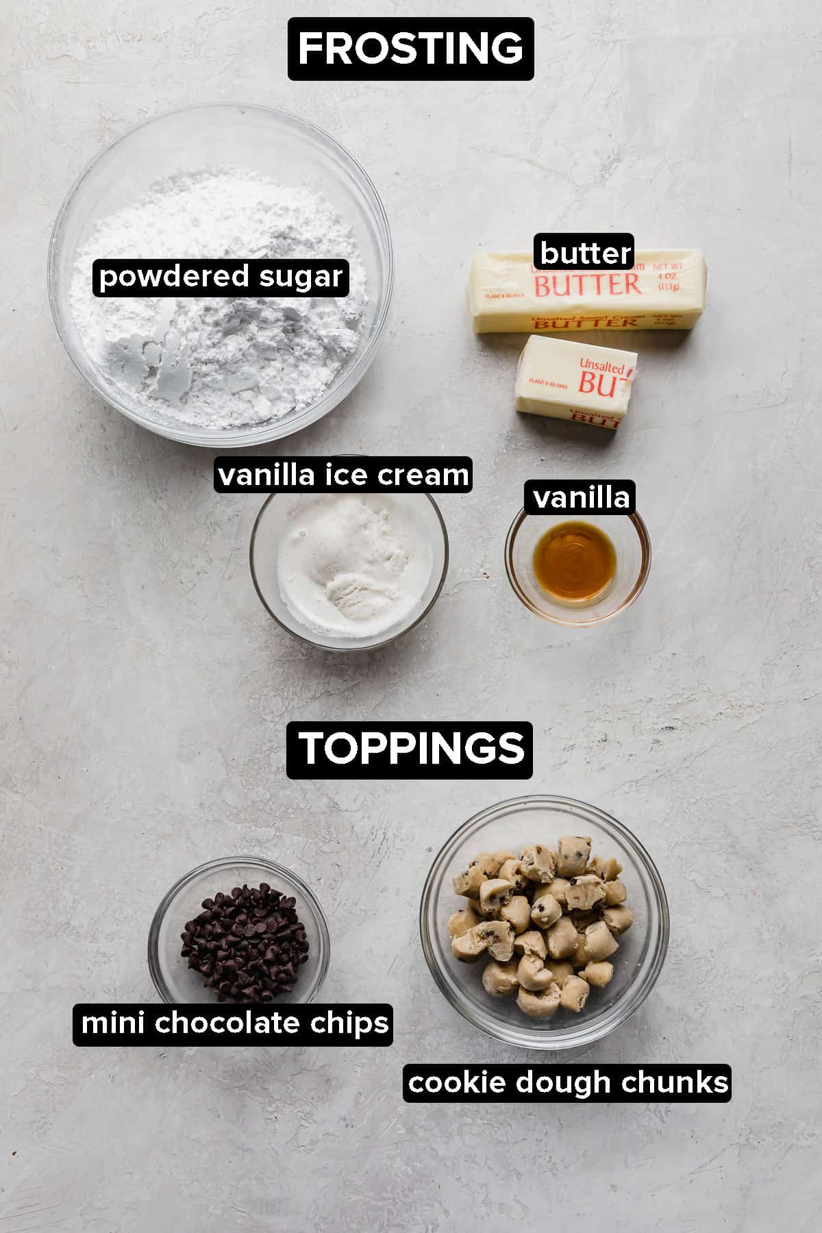 Crumbl Cookie Dough Cookie frosting and topping ingredients on a gray background.