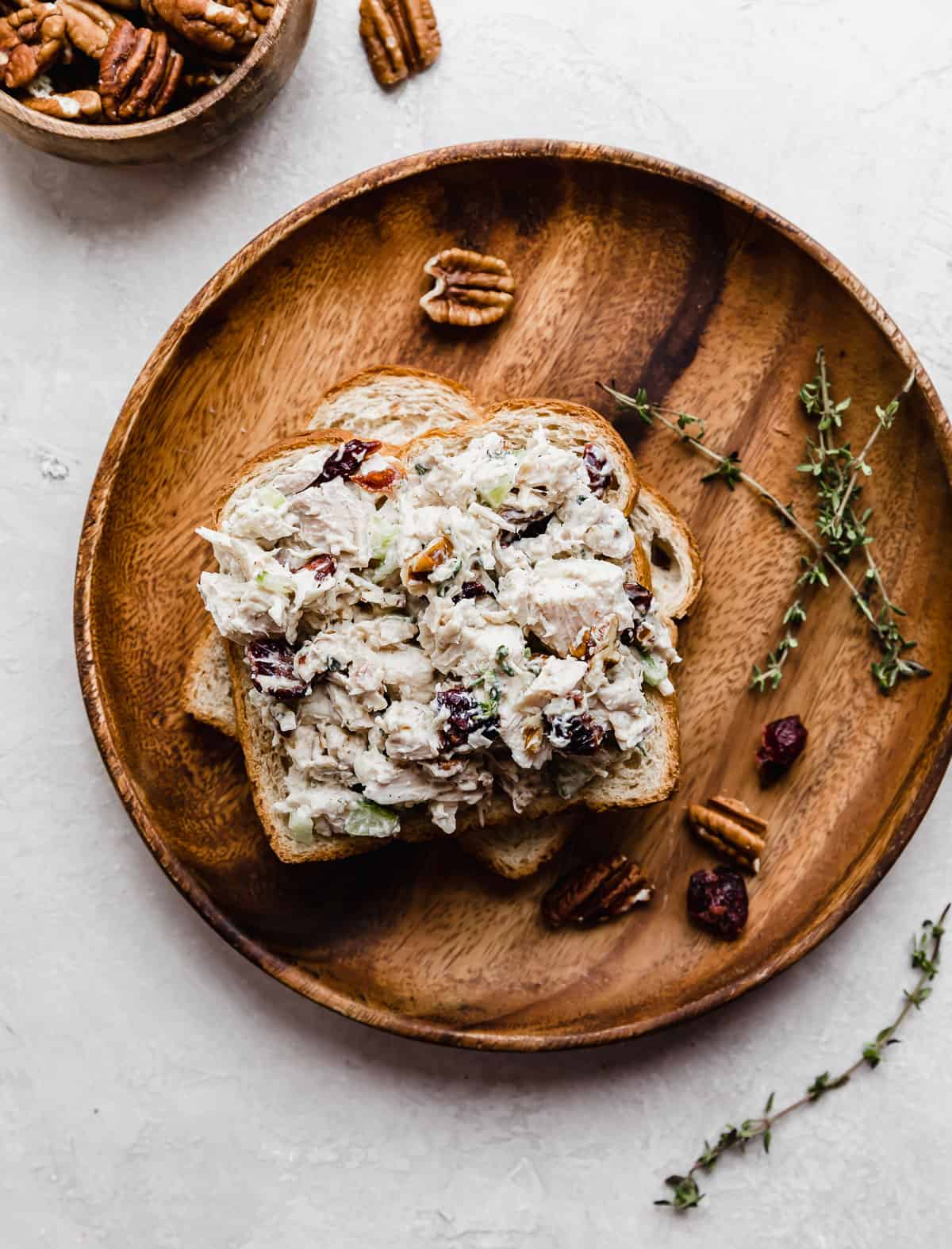 Leftover Cranberry Turkey Salad Sandwich on a slice of bread on a brown circle plate.