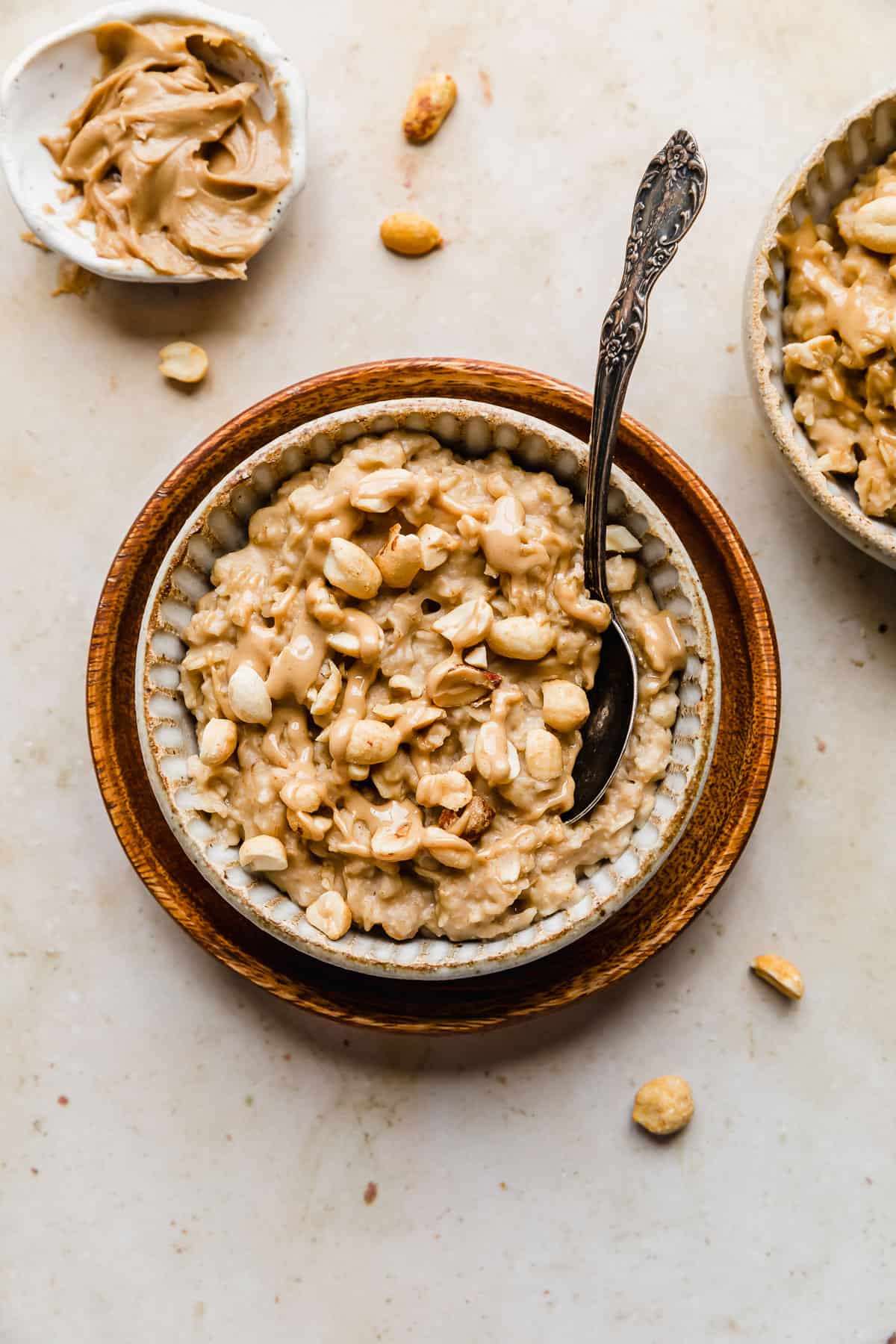Peanut Butter Oatmeal in a ceramic bowl topped with drizzled peanut butter and chopped peanuts.