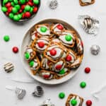 Red and green candy topped Christmas Pretzel Hugs on a white background.