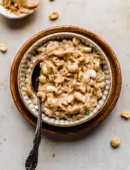 Peanut Butter Oatmeal in a bowl on a tan marble background.