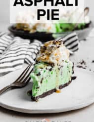 A slice of asphalt pie on a white plate with caramel and crushed Oreos on top.