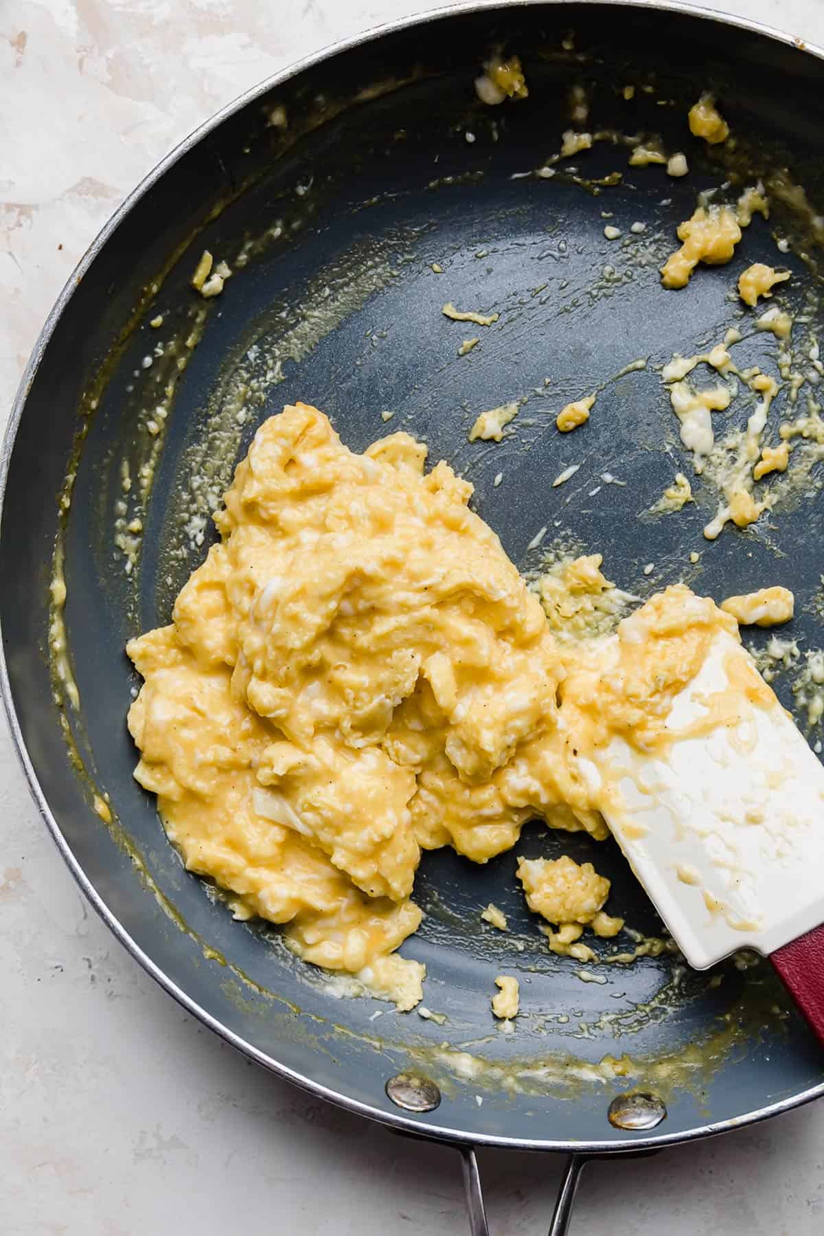 Cheesy Scrambled Eggs in a gray skillet.