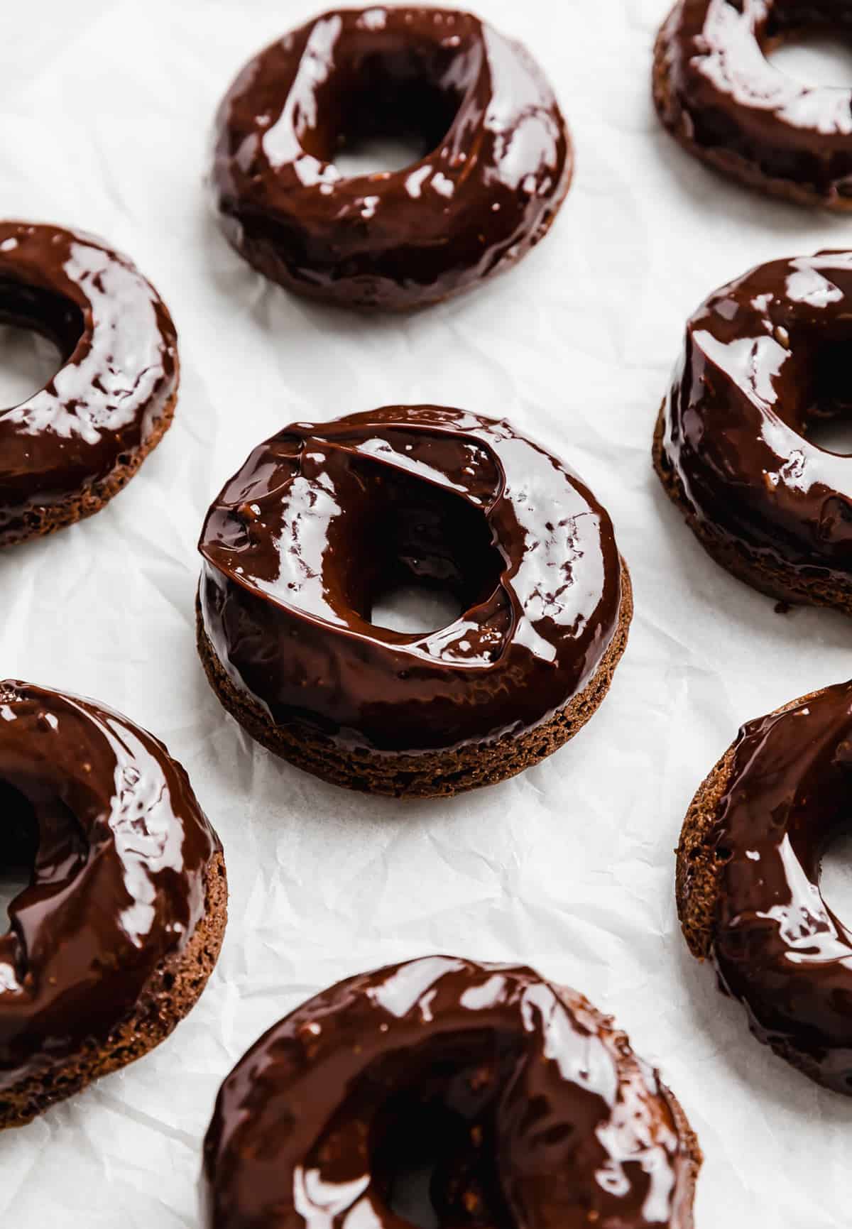 Chocolate Doughnuts topped with a chocolate glaze on white background.
