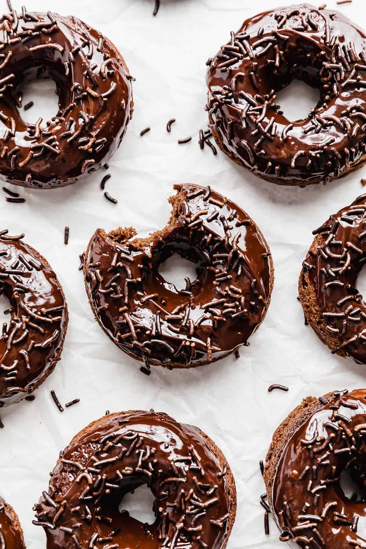 Chocolate Doughnuts topped with chocolate sprinkles on a white background.