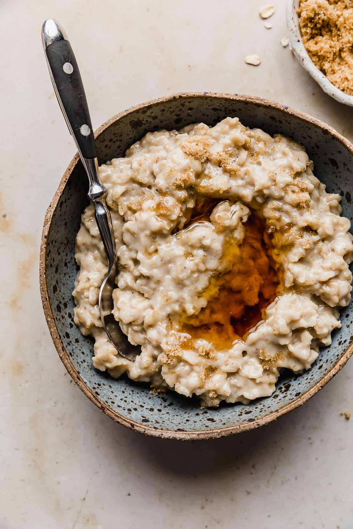 Maple syrup overtop a batch of Maple and Brown Sugar Oatmeal in a bowl.