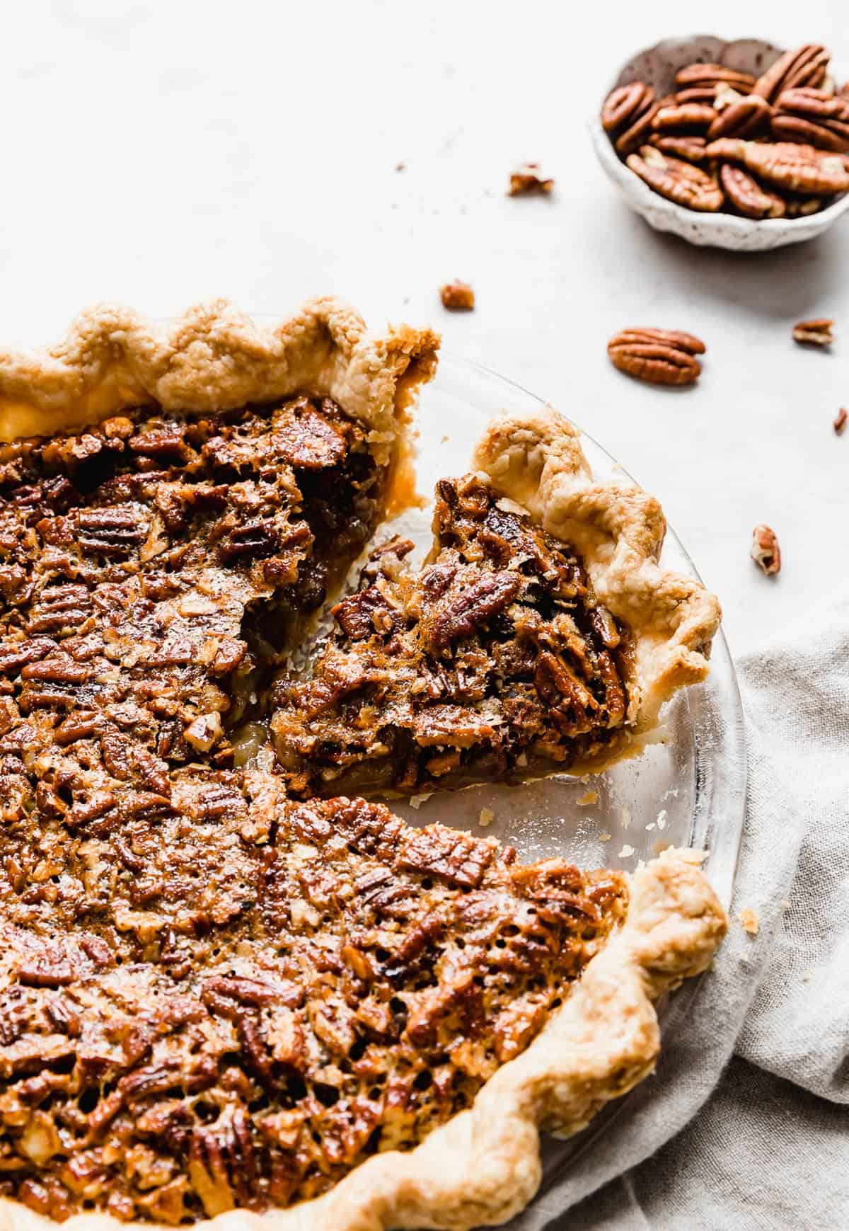 A Southern Pecan Pie Recipe with a slice of pecan pie cut from the whole.