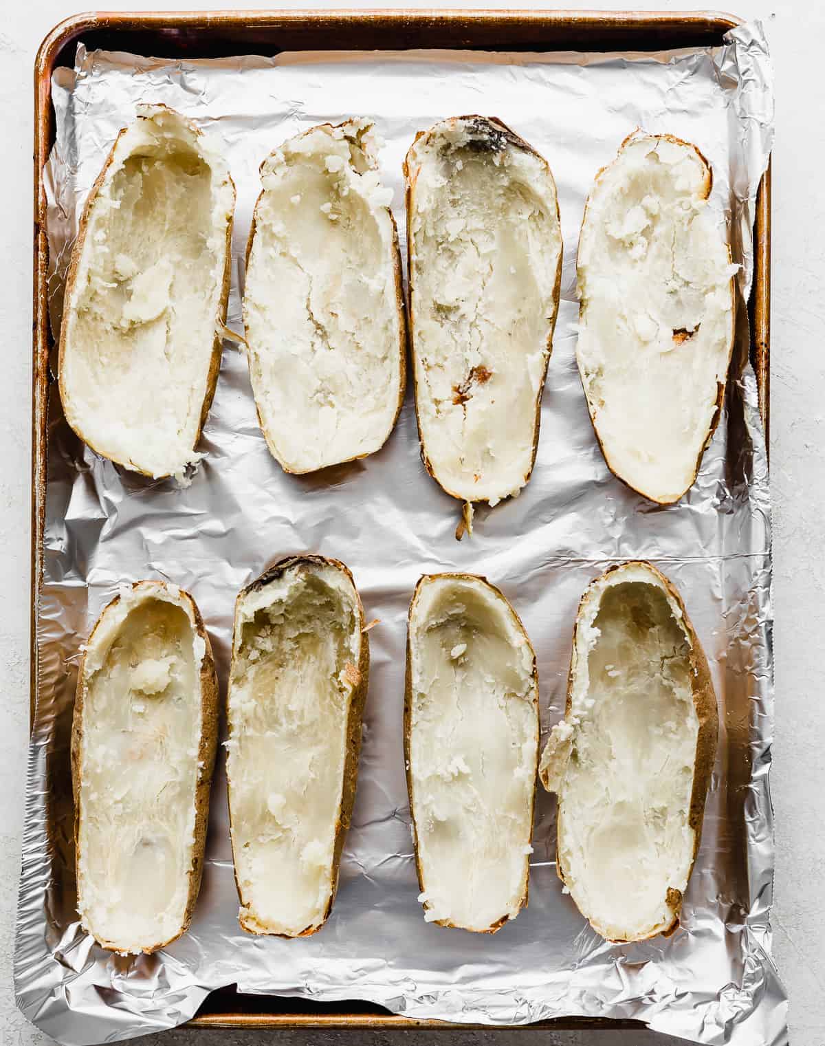 Potato skins on a baking sheet for making Twice Baked Potatoes with Cream Cheese.
