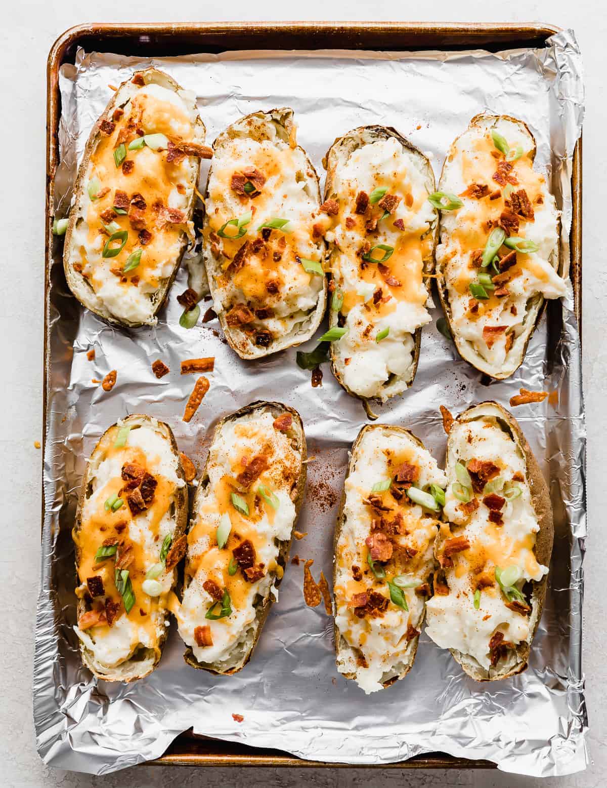 Twice Baked Potatoes with Cream Cheese topped with bacon pieces and sliced green onions. 
