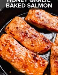 Honey Garlic Baked Salmon in a black skillet bathed in a soy sauce.
