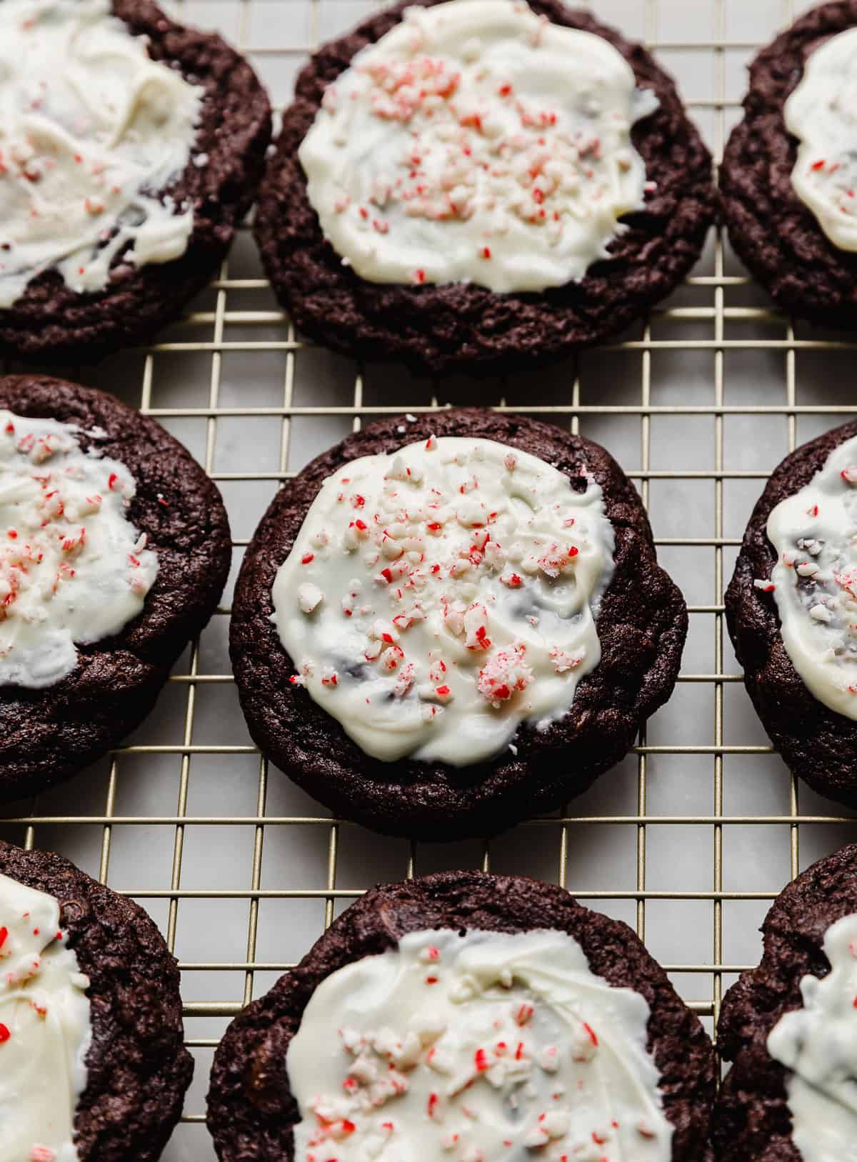Crumbl Peppermint Bark Cookies topped with white melted chocolate and crushed candy canes.