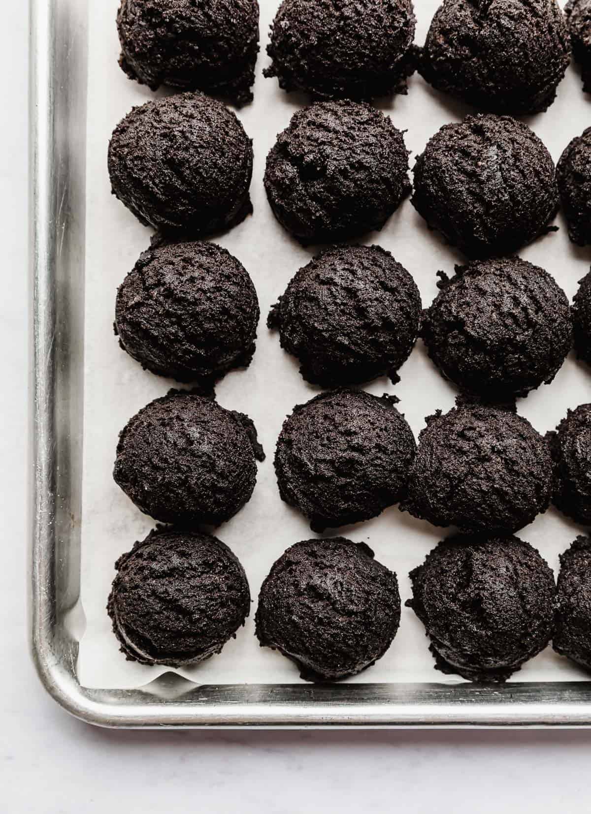 Oreo cookie dough balls on a baking sheet.