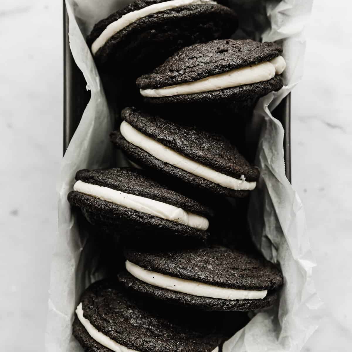 Homemade Oreo Sandwich Cookies in a parchment lined bread pan.