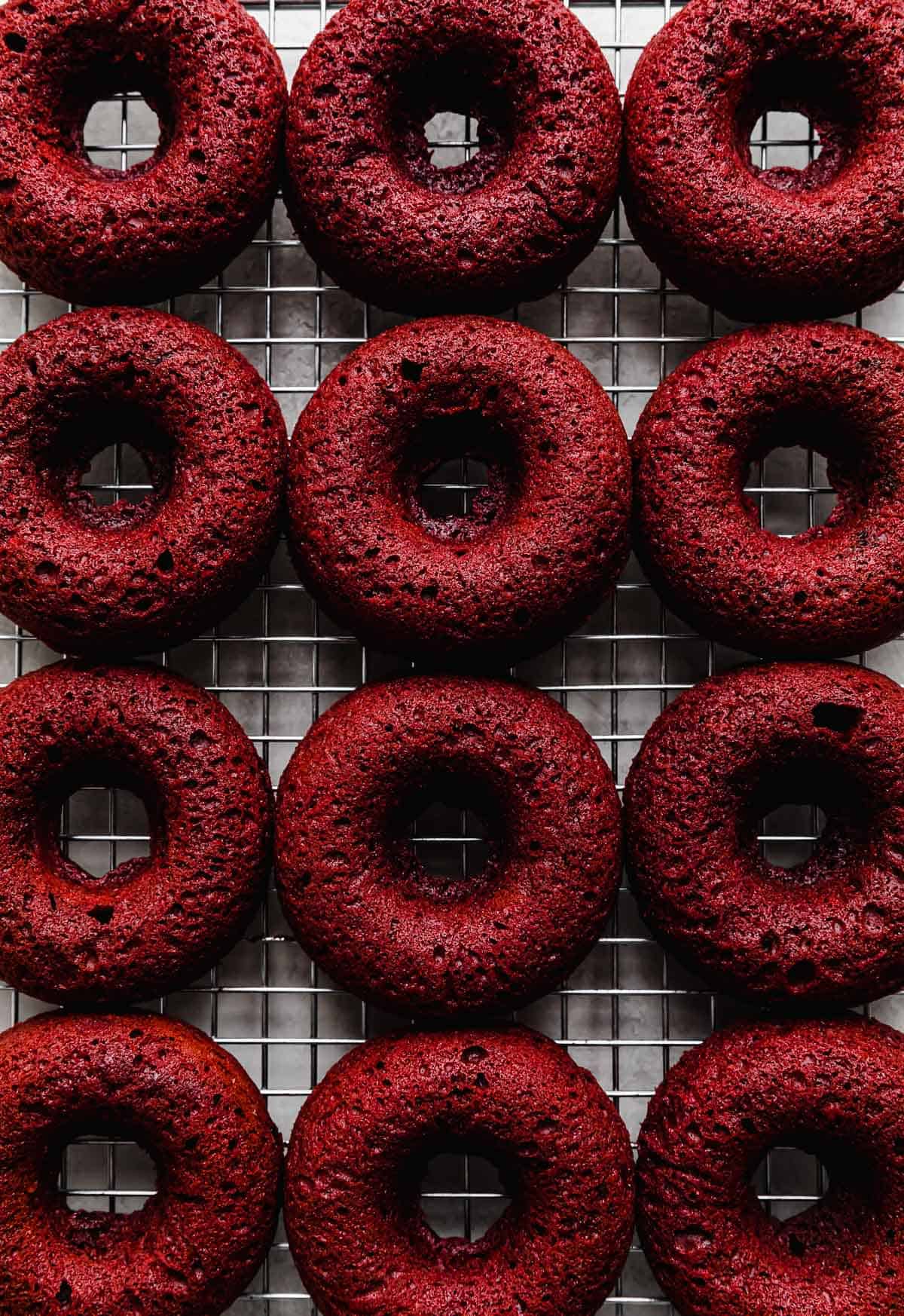 Baked Red Velvet Donuts on a wire cooling rack.