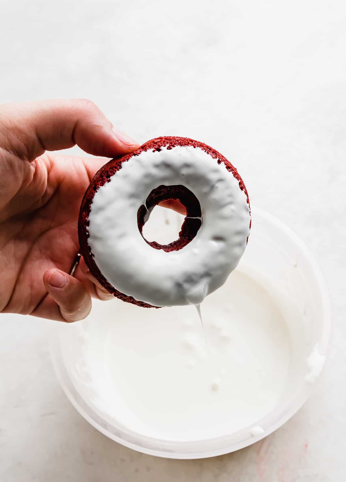 A baked Red Velvet Donut dipped in a white chocolate glaze.