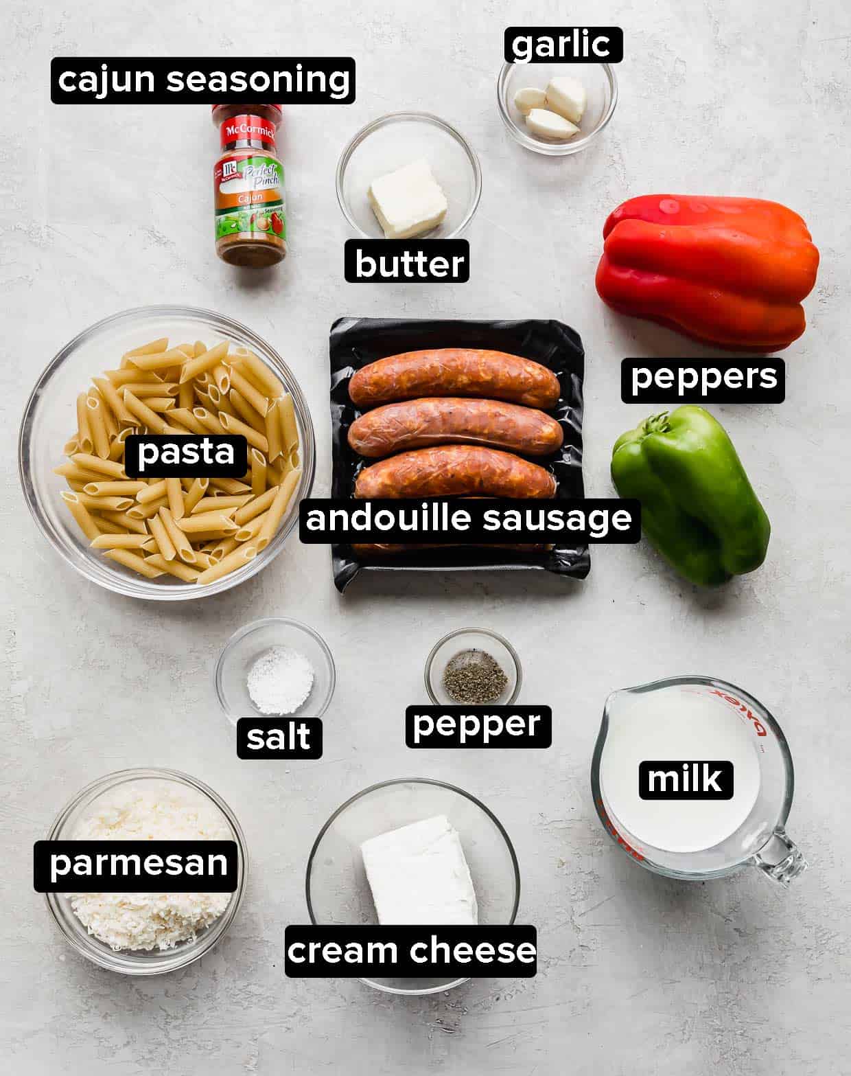 Ingredients used to make Cajun Sausage Pasta on a gray background.