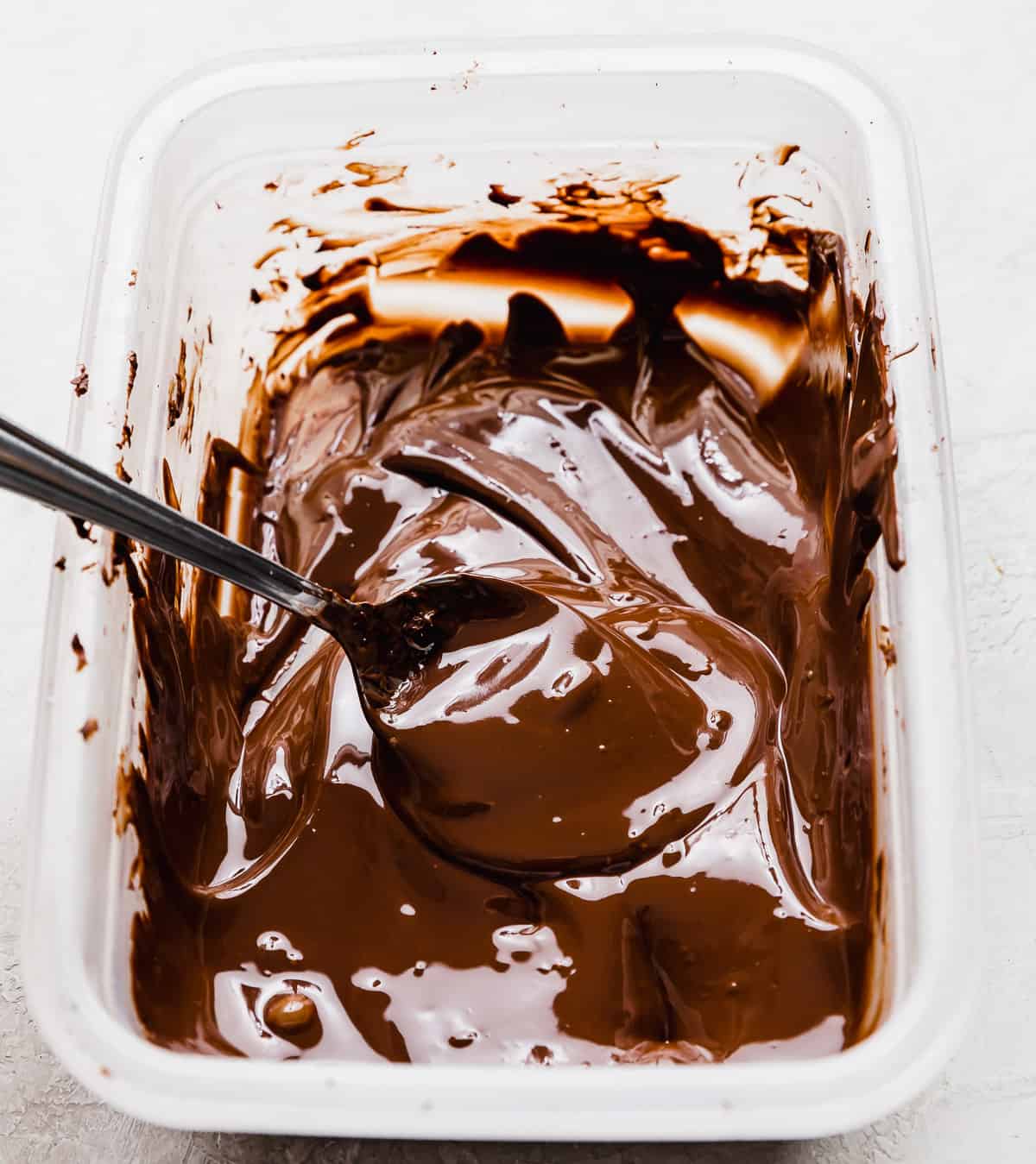 Melted chocolate in a Tupperware container.