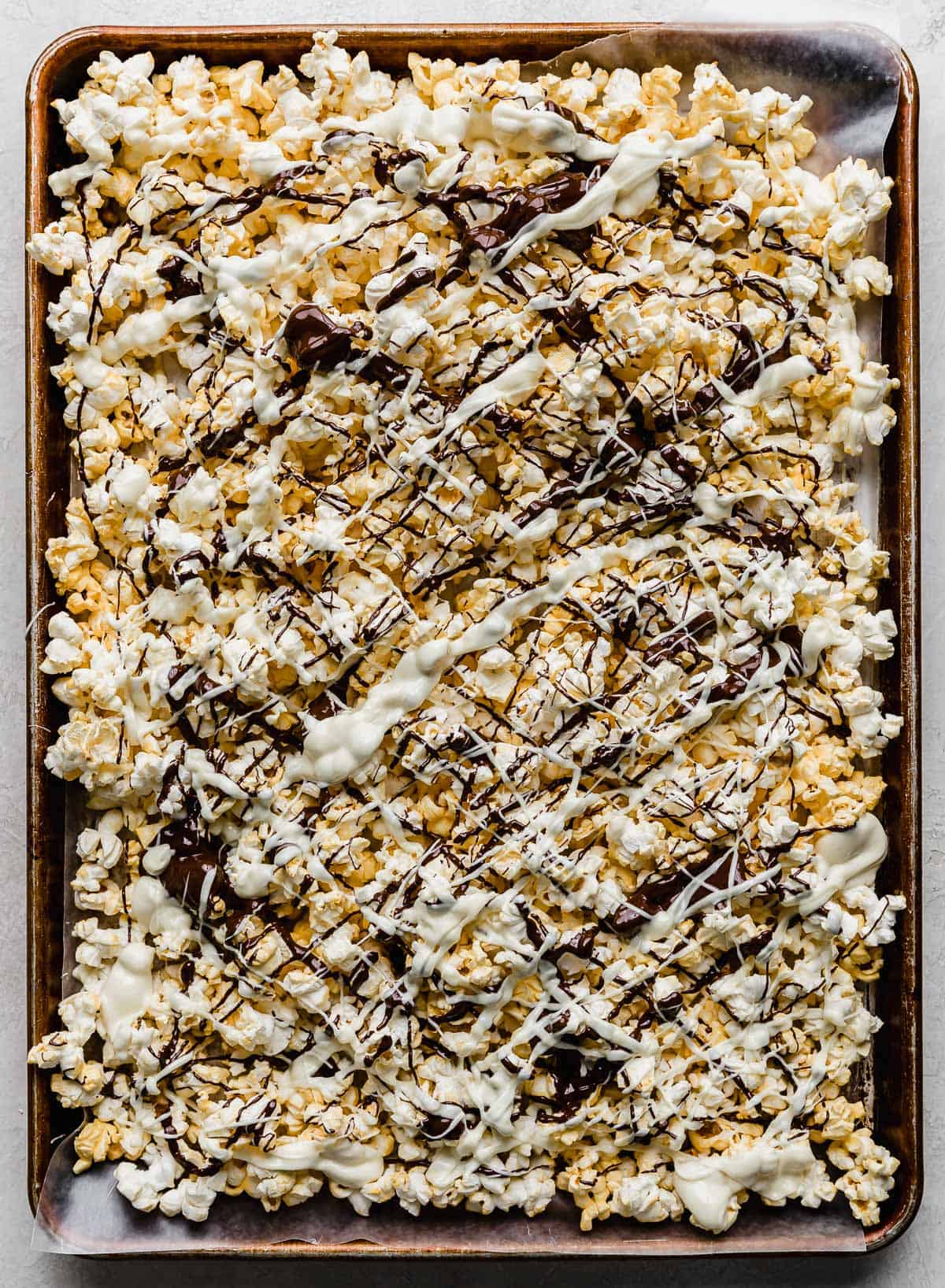 White chocolate and dark chocolate drizzled overtop of popped popcorn.