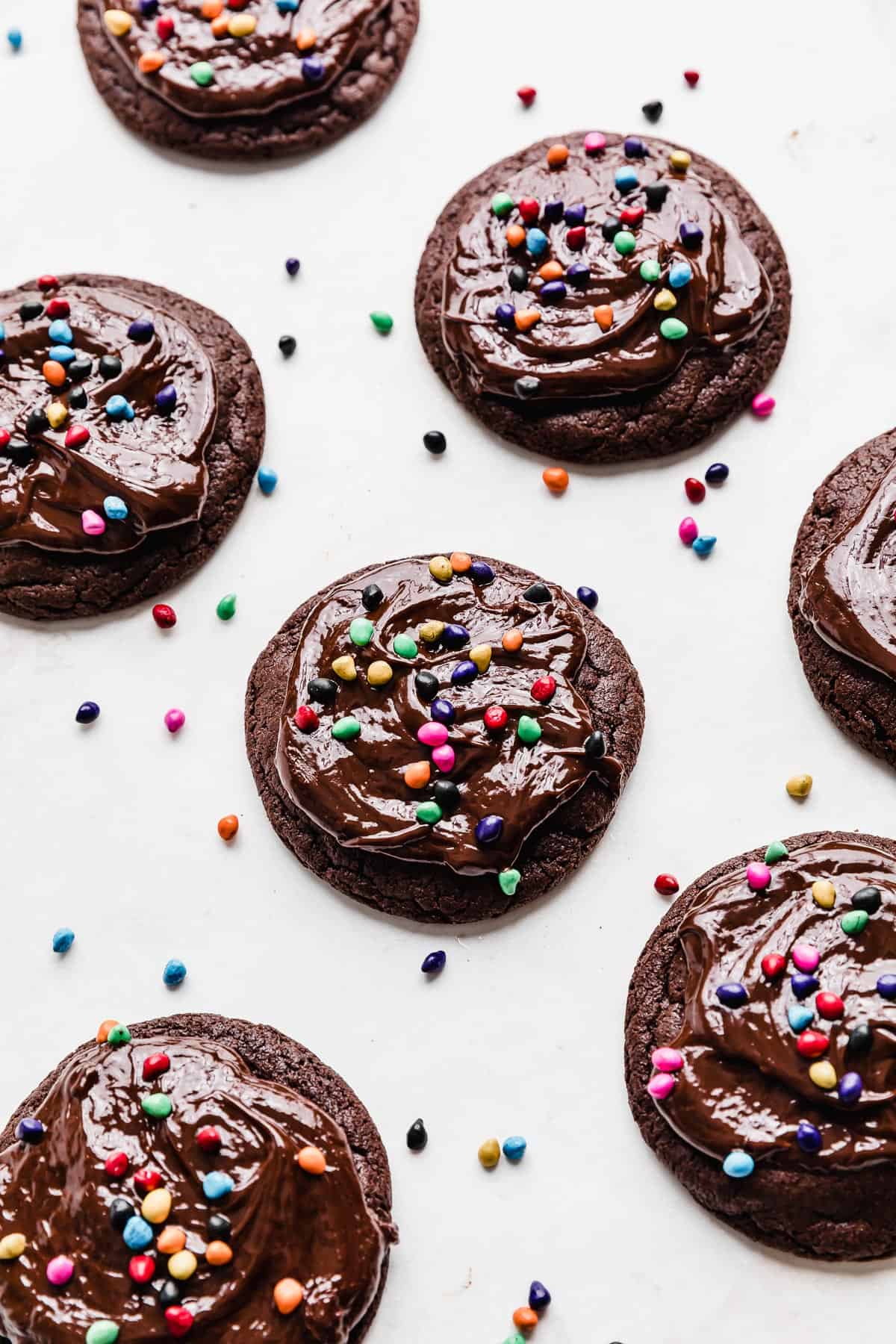 Candy coated sprinkle topped copycat Crumbl cosmic brownie cookies on a white background.