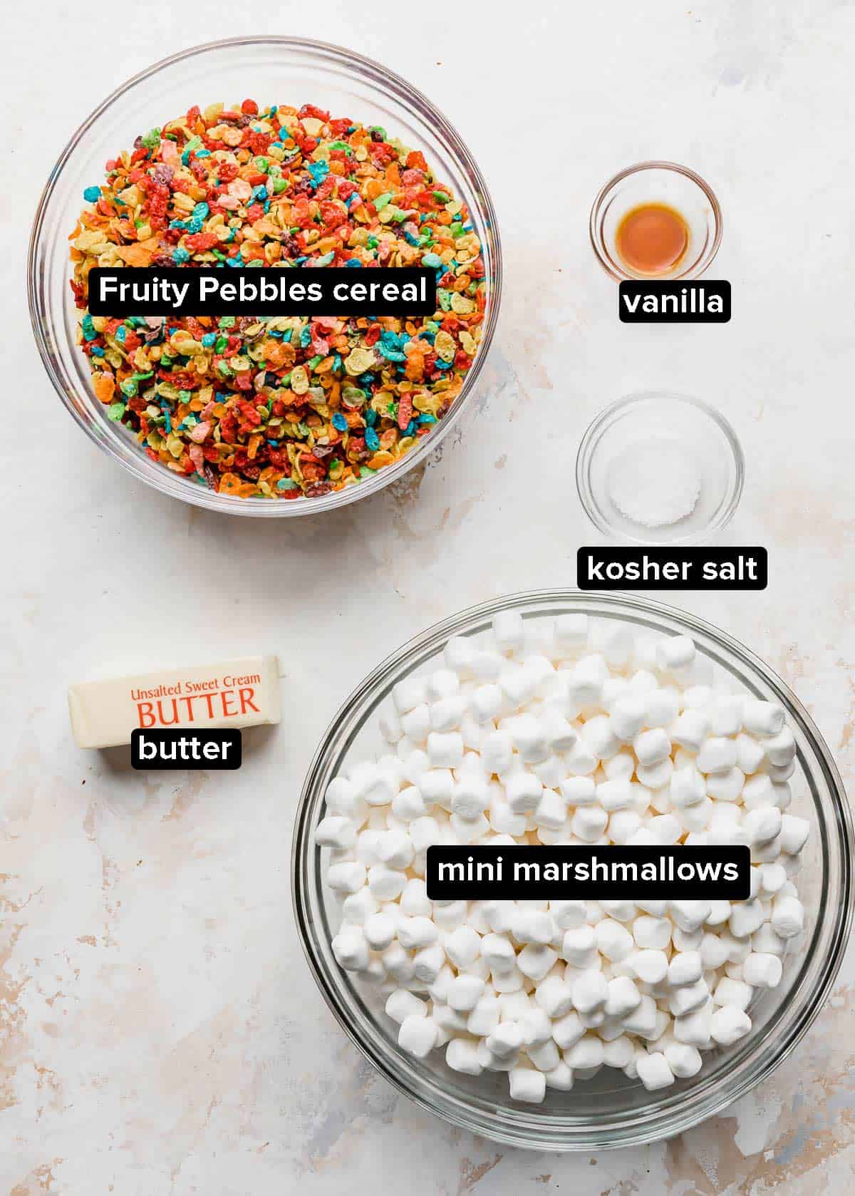 Fruity Pebble Rice Krispie Treats ingredients in glass bowls on a white background.