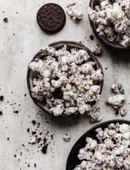 A bowl full of cookies and cream popcorn on a gray background.