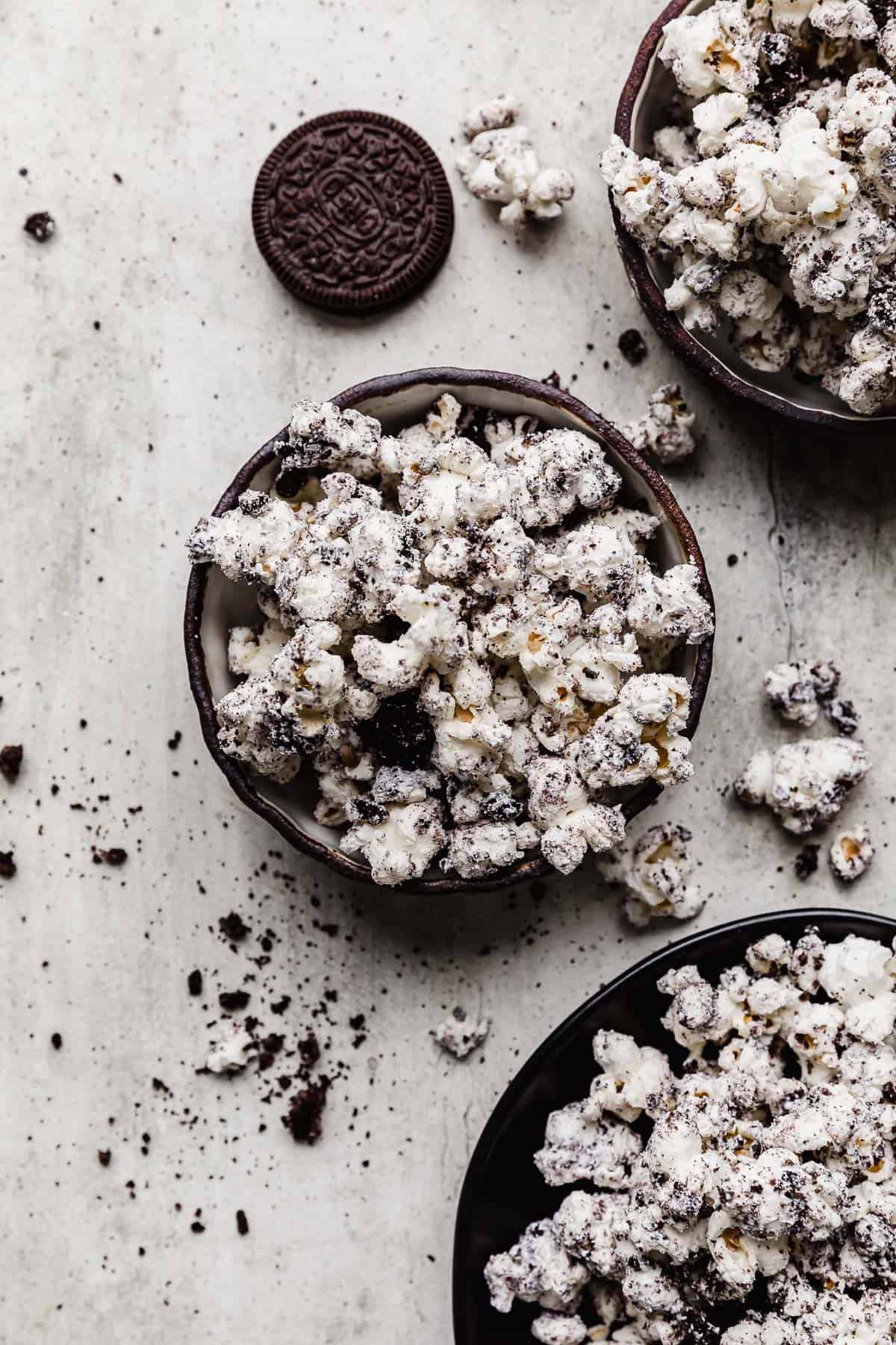 A bowl full of cookies and cream popcorn on a gray background.