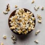 Chocolate Drizzled Popcorn in a bowl on a gray background.