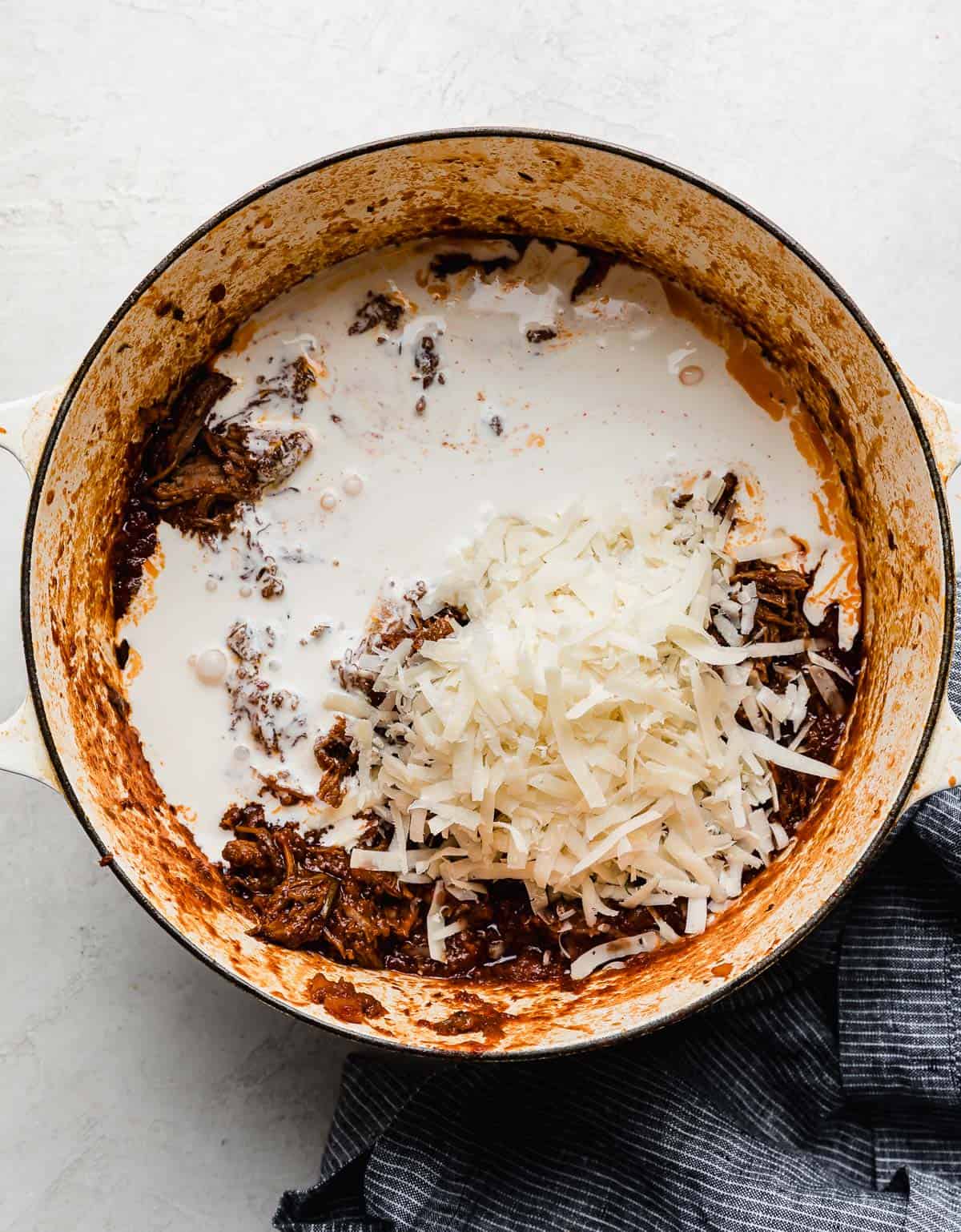Heavy cream and parmesan cheese a top beef Ragu in a large pot.